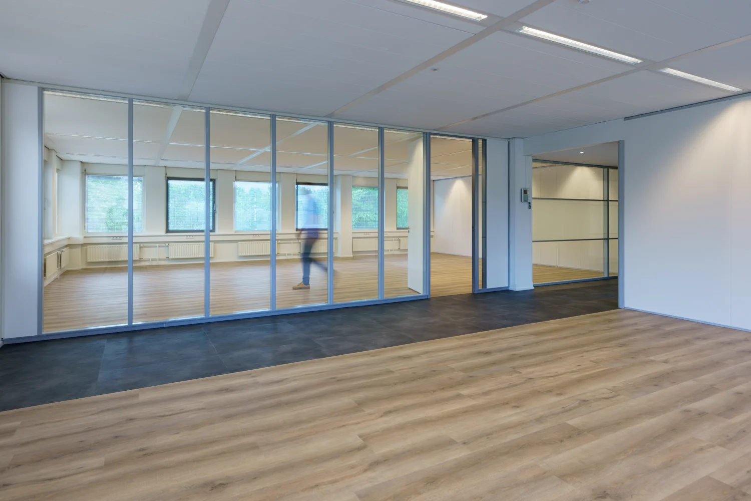 Moderne, lichte kantooruimte aan de Baarnsche Dijk met glazen wanden en houten vloer.